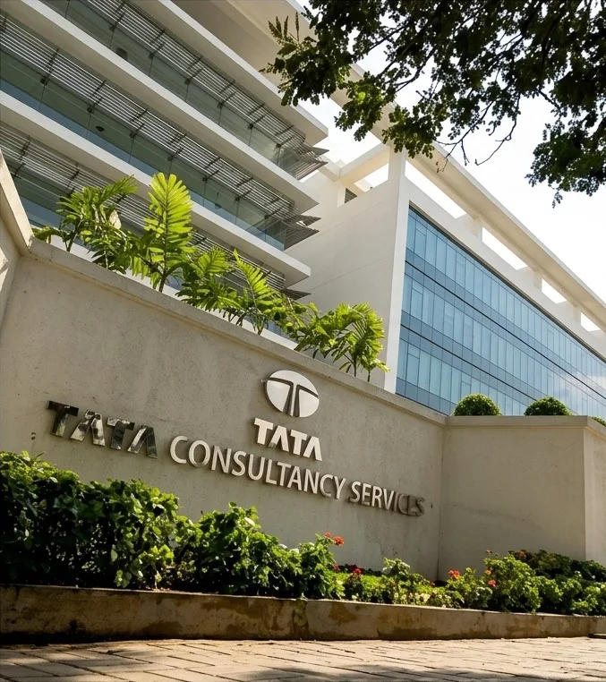 Exterior view of a Tata Consultancy Services (TCS) office building with the company name and logo displayed on the front wall; representative image for TCS Nashik unit news.