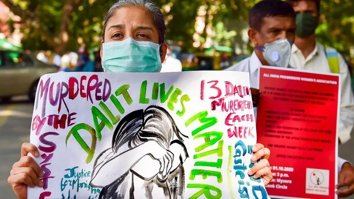 Protesters holding signs that read "Dalit Lives Matter" and "Murdered by the Caste System" during a demonstration.