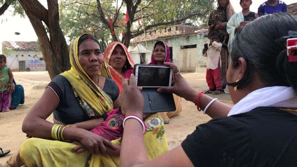 Khabar Lahariya journalist Suneeta reporting on location in Chitrakoot, Uttar Pradesh using a smartphone.